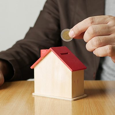 Picture of Man Putting Coin into House